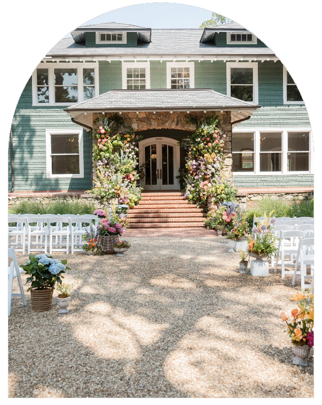 A wedding ceremony taking place in a front yard, decorated with flowers and chairs for guests.