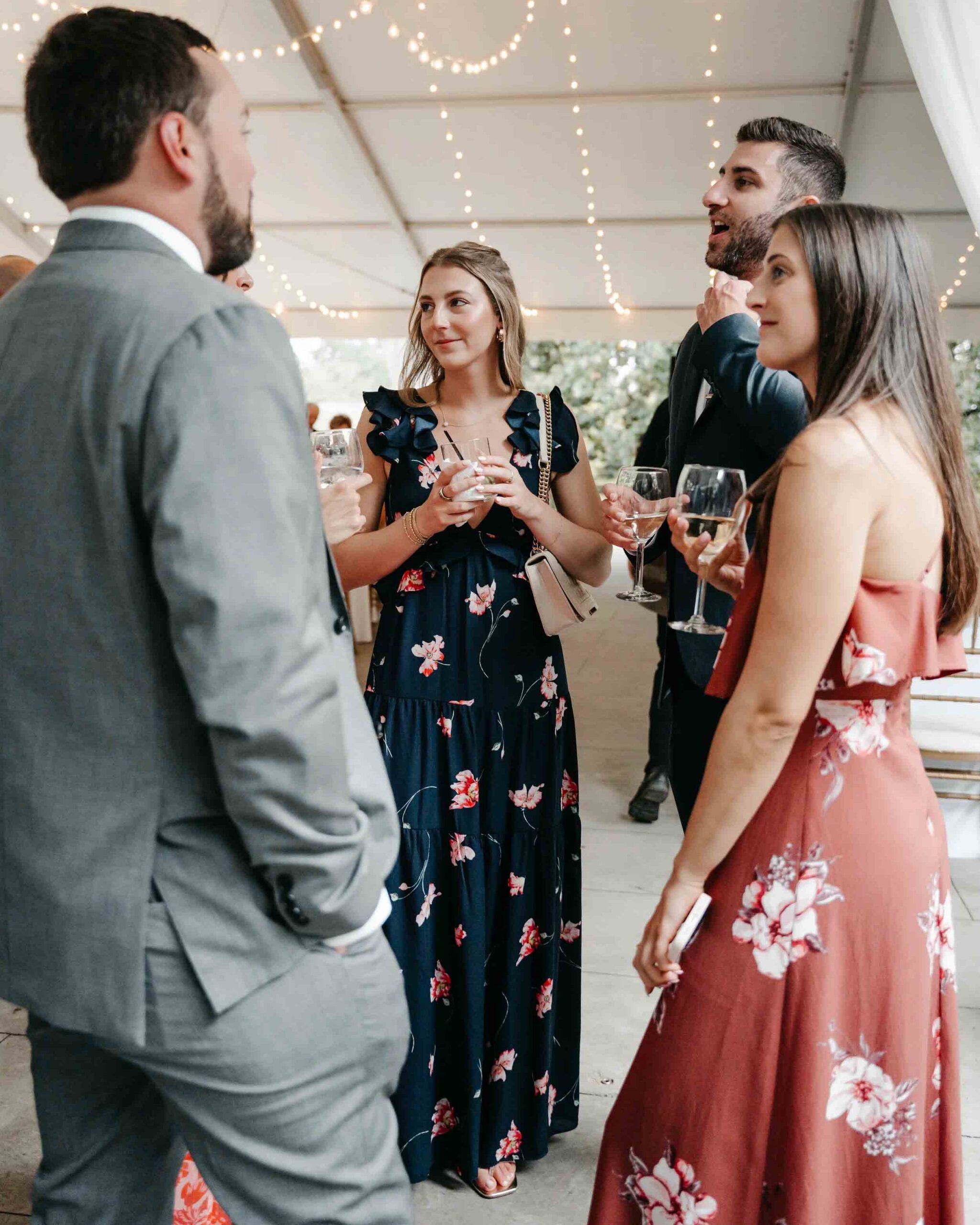 A black and white photo capturing a wedding dinner setting with elegantly arranged tables and guests enjoying the celebration.