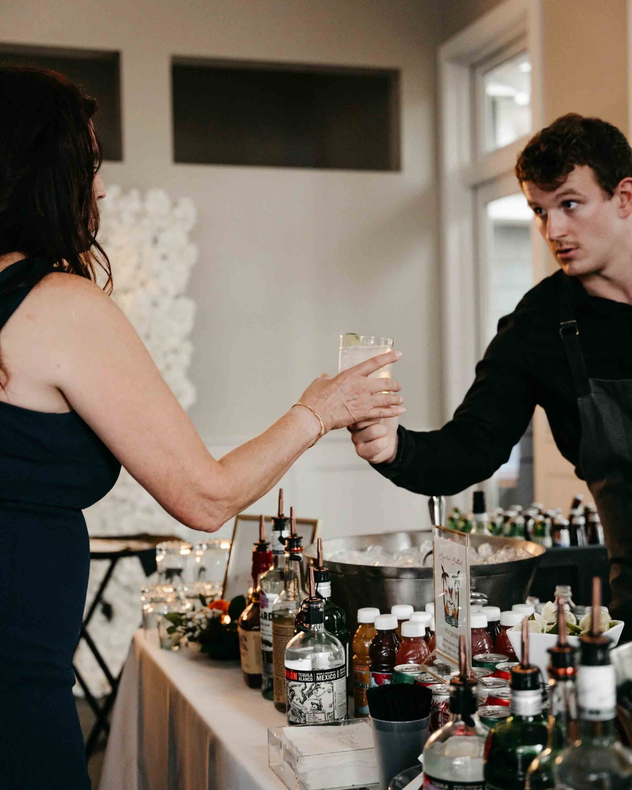 A man and woman clink glasses in a toast at a bar, smiling and enjoying their time together.