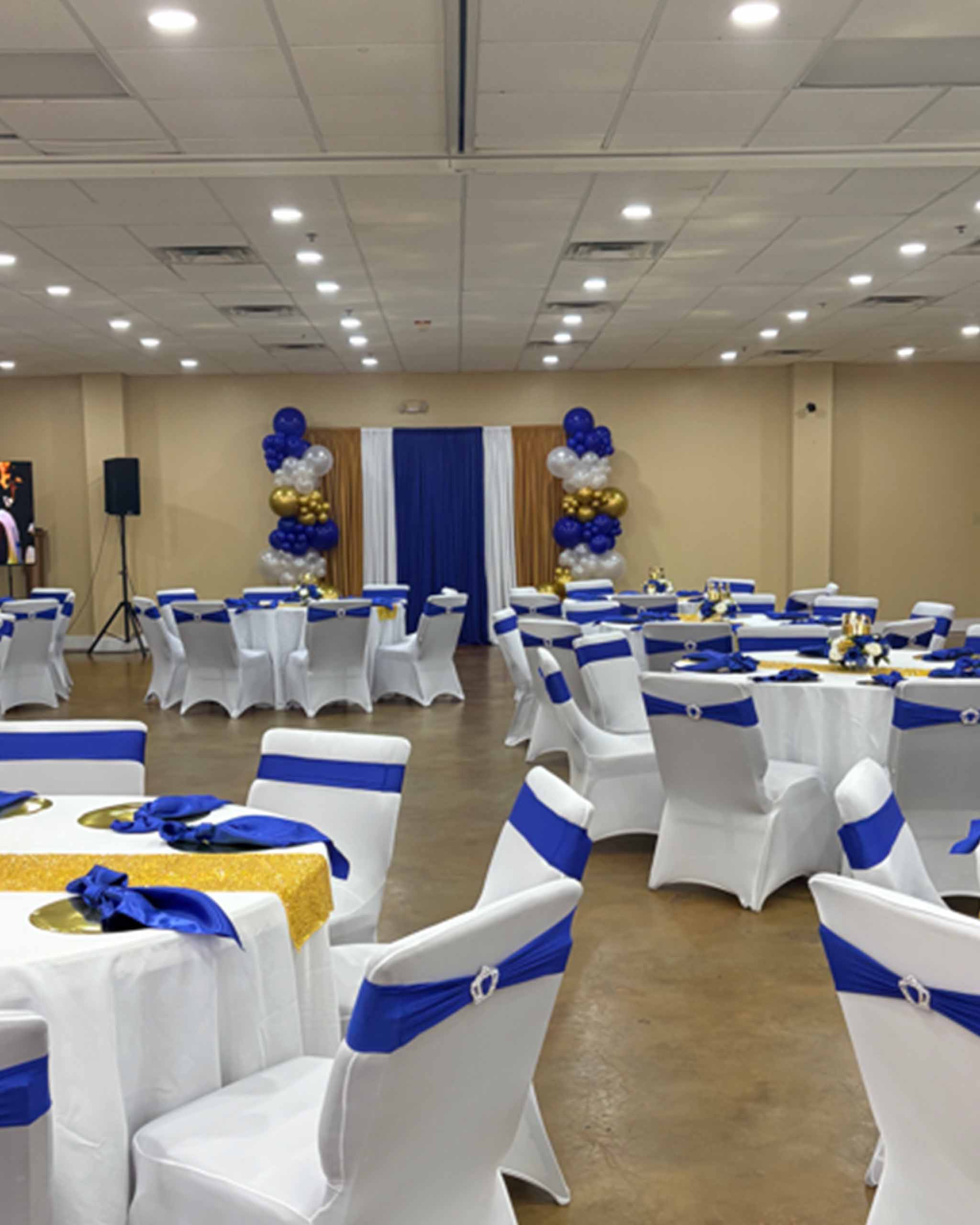 A banquet room adorned with elegant blue and white decorations, featuring tables set for a formal event.